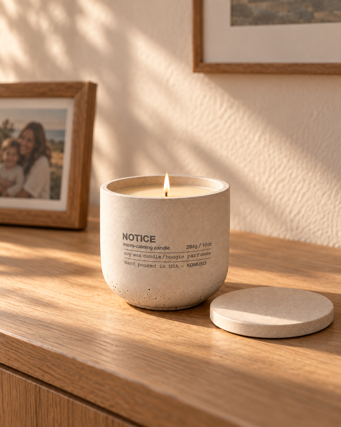 Lit NOTICE candle on an oak console in a warm home